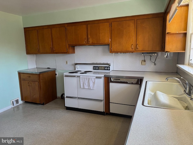 kitchen featuring decorative backsplash, sink, and white appliances