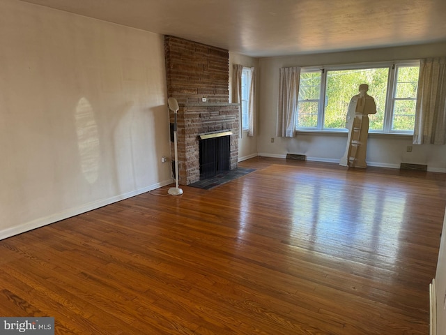 unfurnished living room with a fireplace and dark hardwood / wood-style floors