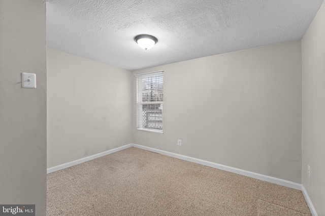 spare room featuring carpet flooring and a textured ceiling