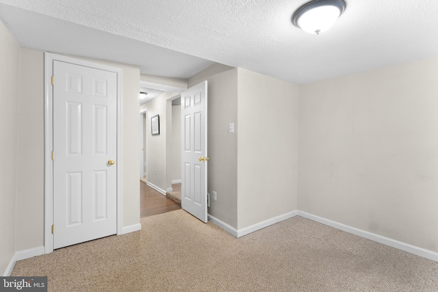 carpeted spare room with a textured ceiling