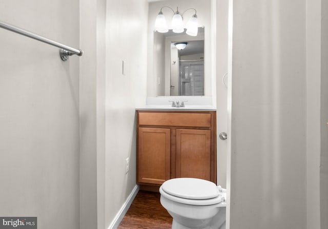 bathroom with hardwood / wood-style floors, vanity, and toilet