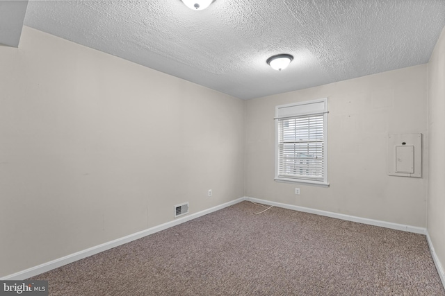 carpeted empty room featuring a textured ceiling