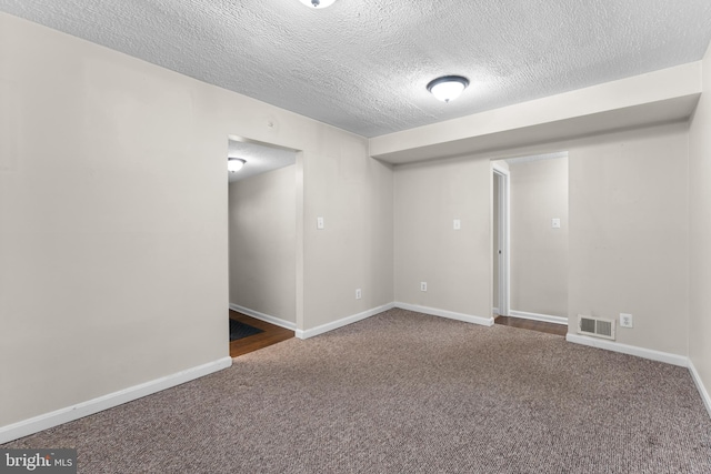 carpeted spare room featuring a textured ceiling