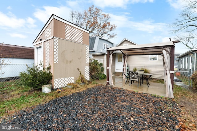 back of property with a patio and a storage unit