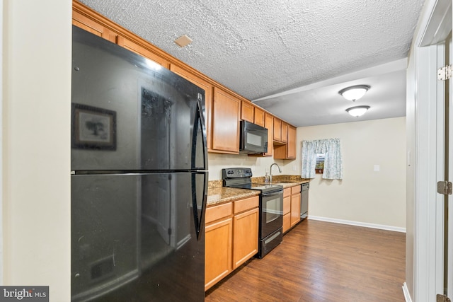 kitchen featuring a textured ceiling, sink, dark wood-type flooring, and black appliances