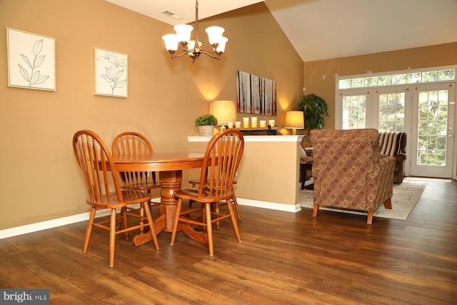 dining space with dark wood-type flooring, high vaulted ceiling, and an inviting chandelier