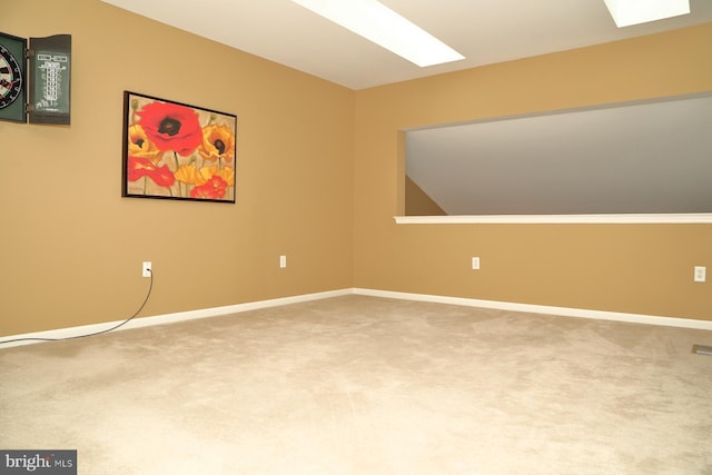 empty room featuring carpet flooring and a skylight