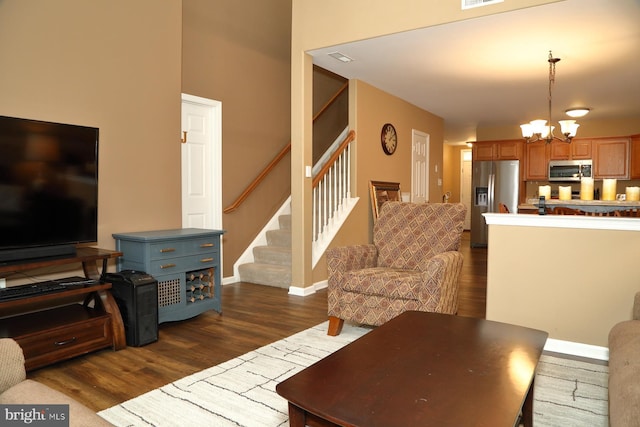 living room with dark hardwood / wood-style floors and a notable chandelier