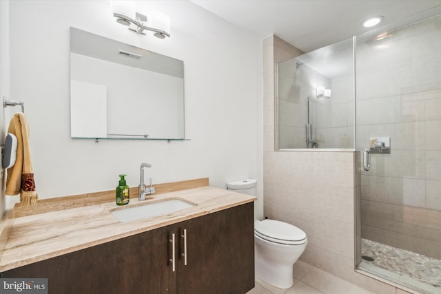 bathroom featuring tile patterned floors, vanity, toilet, and an enclosed shower