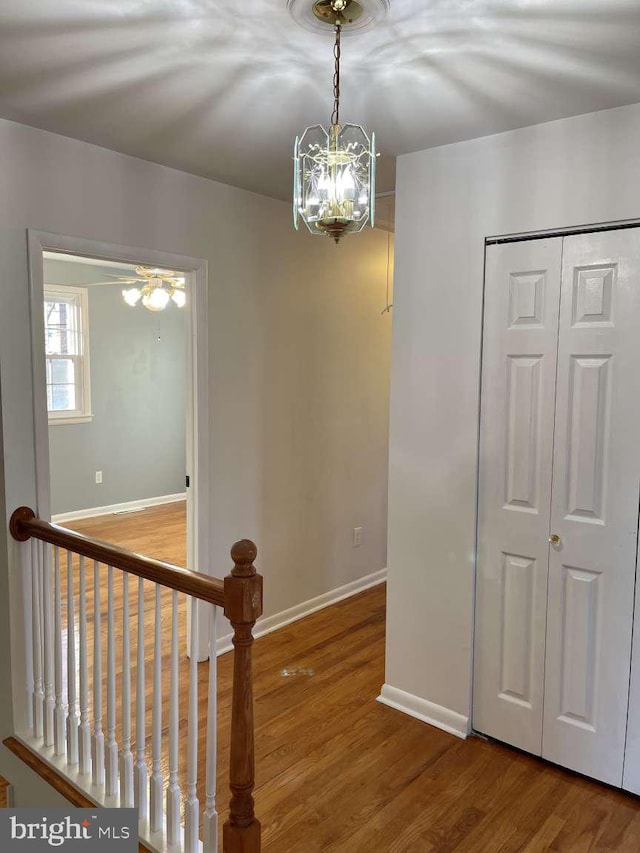 hallway with a notable chandelier and wood-type flooring