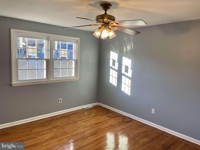 spare room featuring wood-type flooring and ceiling fan