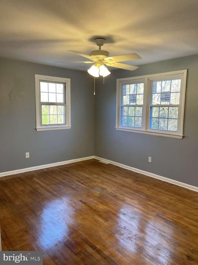 unfurnished room with ceiling fan and dark wood-type flooring