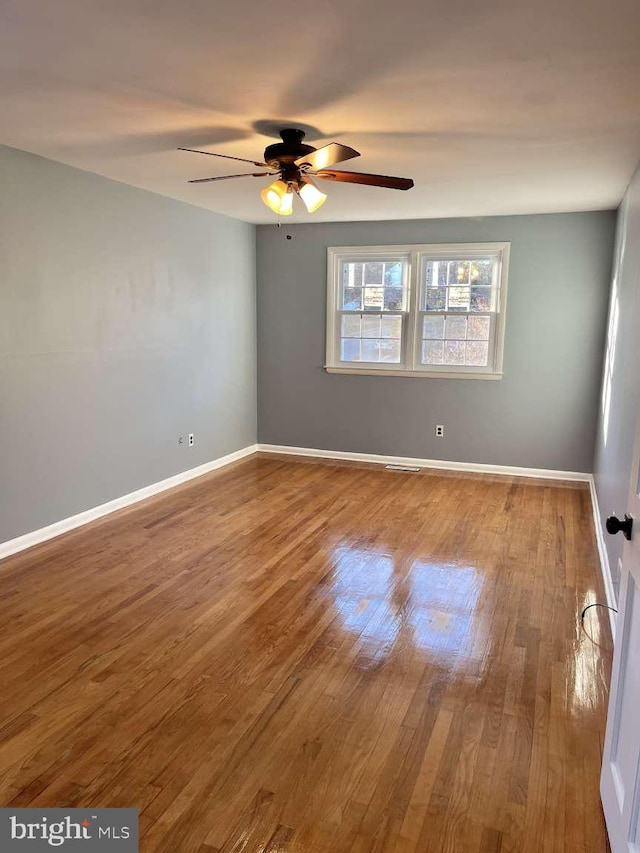 empty room with ceiling fan and wood-type flooring