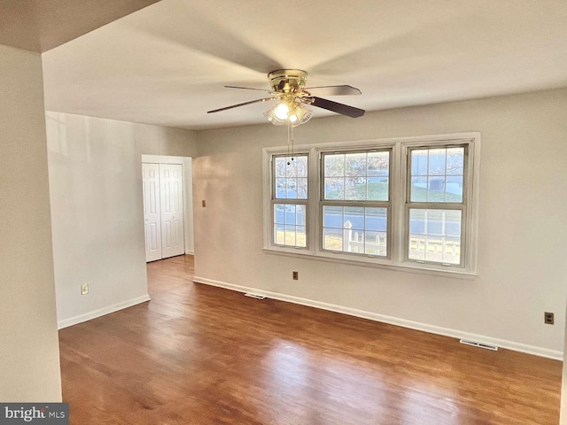 empty room featuring ceiling fan and dark hardwood / wood-style flooring