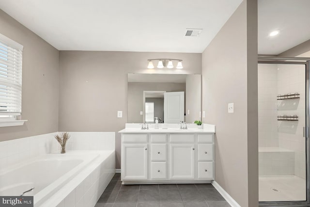 bathroom featuring tile patterned flooring, vanity, and plus walk in shower