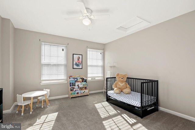 carpeted bedroom with ceiling fan and a nursery area