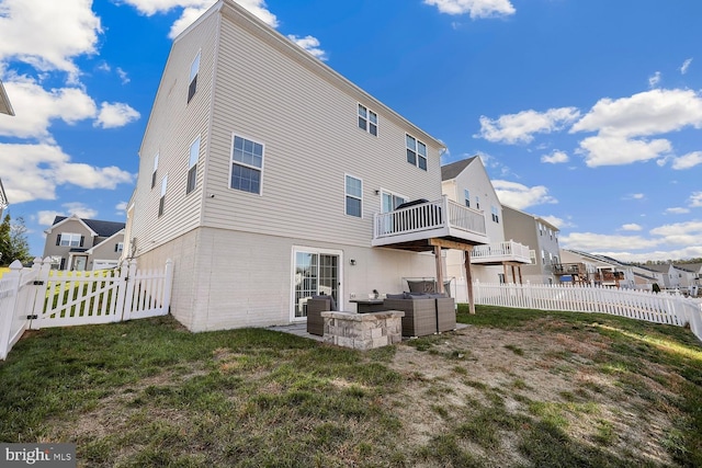 rear view of property with a lawn and a balcony