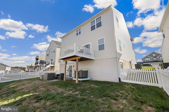 back of property featuring a lawn, an outdoor living space, and a deck