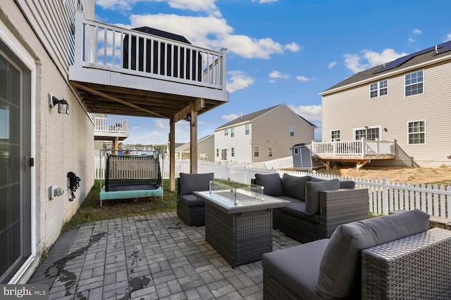 view of patio featuring a deck and an outdoor living space with a fire pit