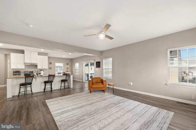 sitting room with ceiling fan, sink, and dark wood-type flooring