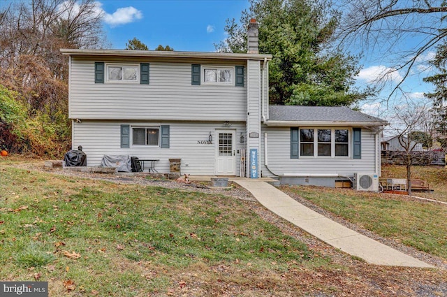 view of front of home featuring ac unit and a front lawn