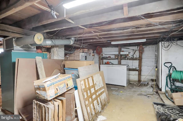 basement featuring white fridge and electric water heater