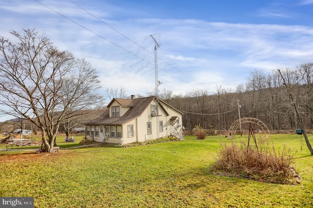 view of property exterior featuring a sunroom and a yard