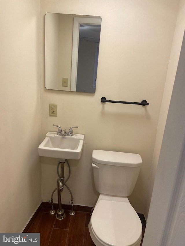 bathroom featuring hardwood / wood-style floors, toilet, and sink