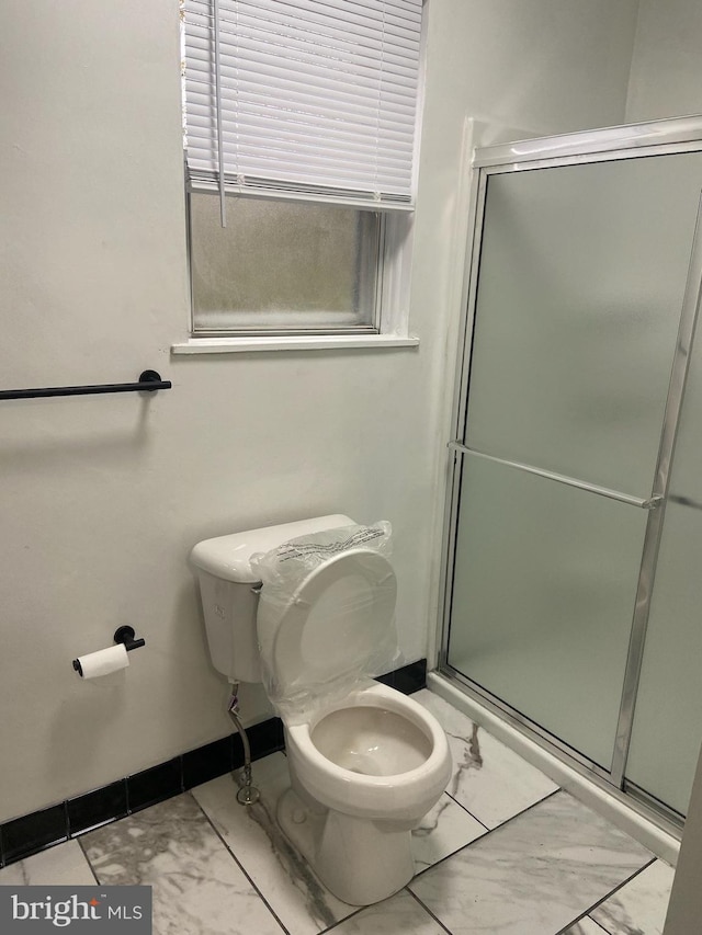 bathroom featuring an enclosed shower and toilet