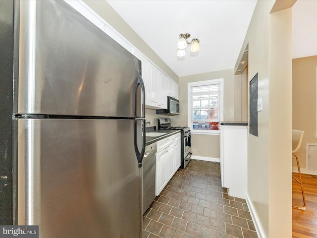 kitchen featuring dark wood-type flooring, white cabinets, and stainless steel appliances