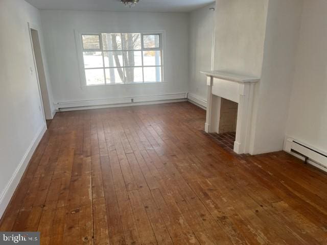 unfurnished living room with dark hardwood / wood-style flooring and a baseboard heating unit