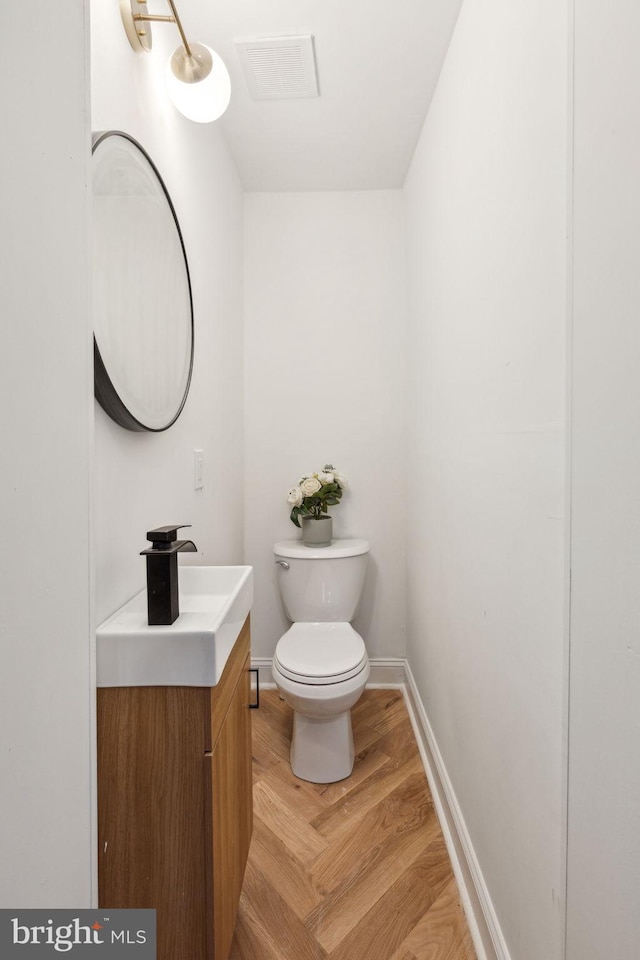 bathroom with hardwood / wood-style floors, vanity, and toilet