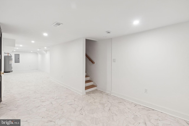 basement featuring electric panel and water heater