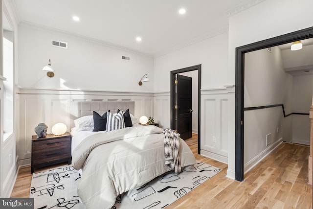 bedroom with crown molding and light hardwood / wood-style floors