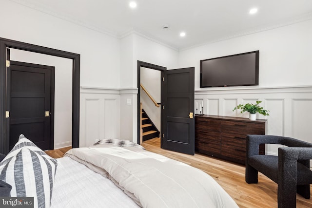 bedroom with crown molding and hardwood / wood-style flooring