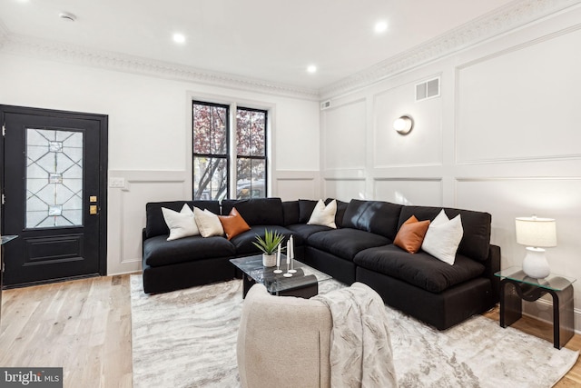 living room featuring light hardwood / wood-style floors and ornamental molding