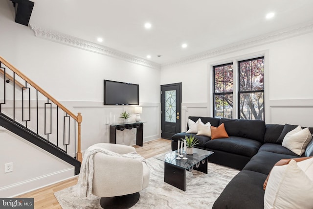 living room with light wood-type flooring and crown molding