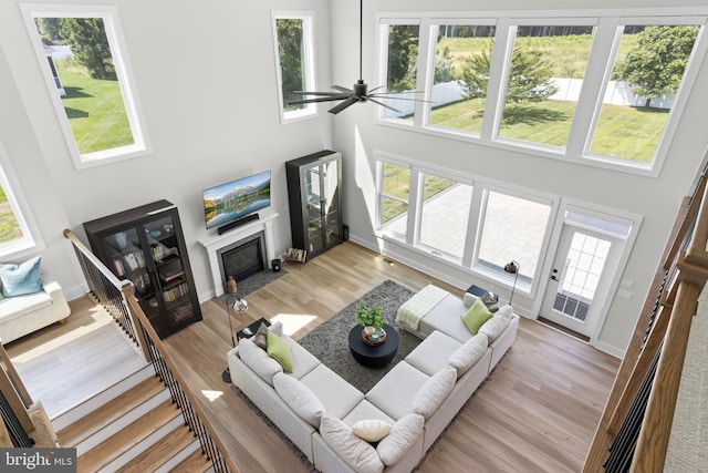 living room with plenty of natural light, a high ceiling, and light wood-type flooring