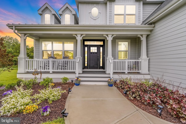 exterior entry at dusk featuring a porch