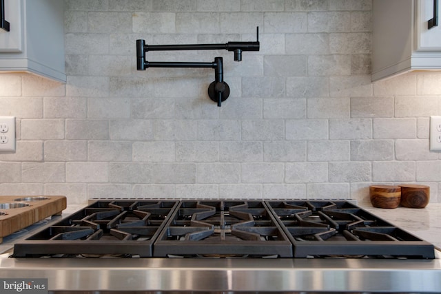 room details with tasteful backsplash and stainless steel range with gas cooktop