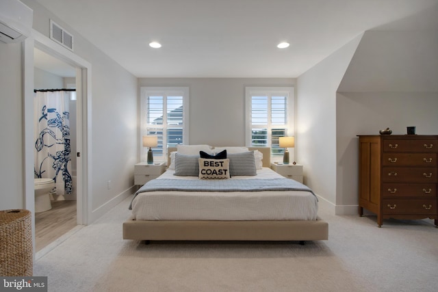 bedroom featuring light carpet and a wall unit AC