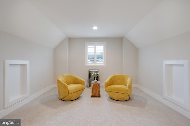 sitting room with vaulted ceiling and carpet flooring