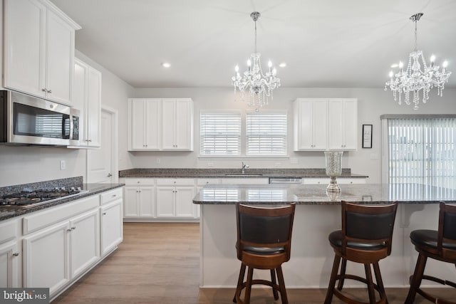 kitchen featuring white cabinets, stainless steel appliances, and light hardwood / wood-style flooring