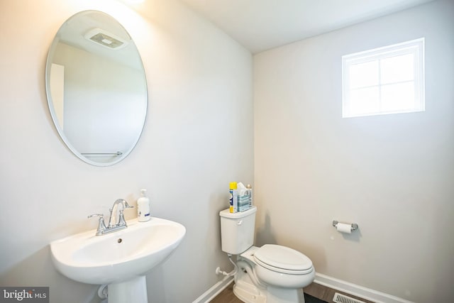 bathroom featuring toilet, wood-type flooring, and sink