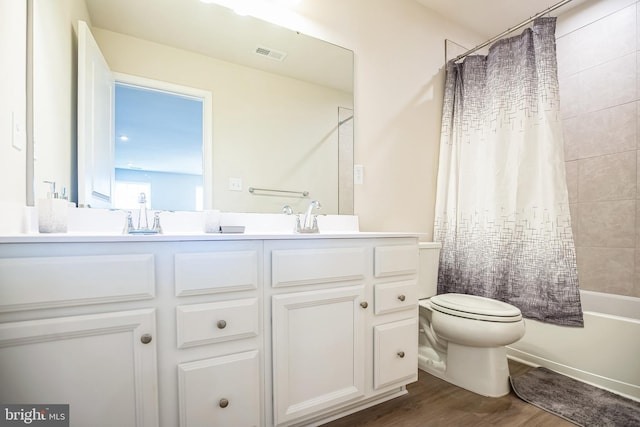 full bathroom featuring toilet, hardwood / wood-style floors, vanity, and shower / tub combo with curtain