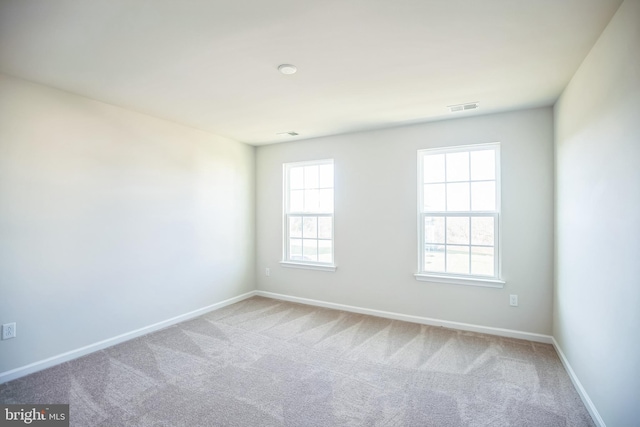 carpeted spare room featuring a healthy amount of sunlight