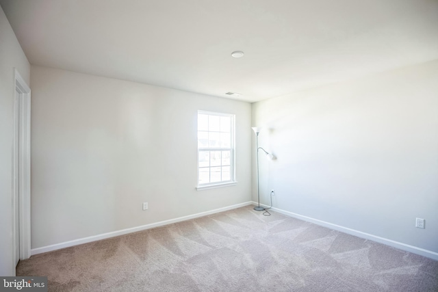 spare room featuring light carpet