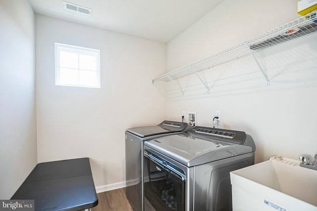 washroom featuring independent washer and dryer, dark hardwood / wood-style floors, and sink