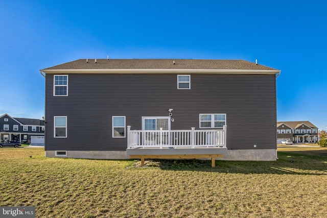 back of house featuring a lawn and a wooden deck