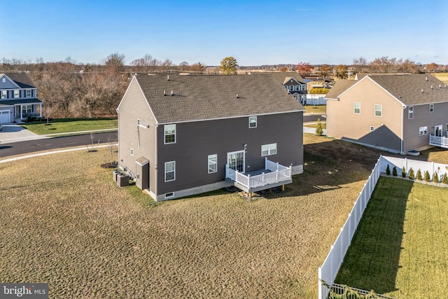 back of property with central AC unit and a yard